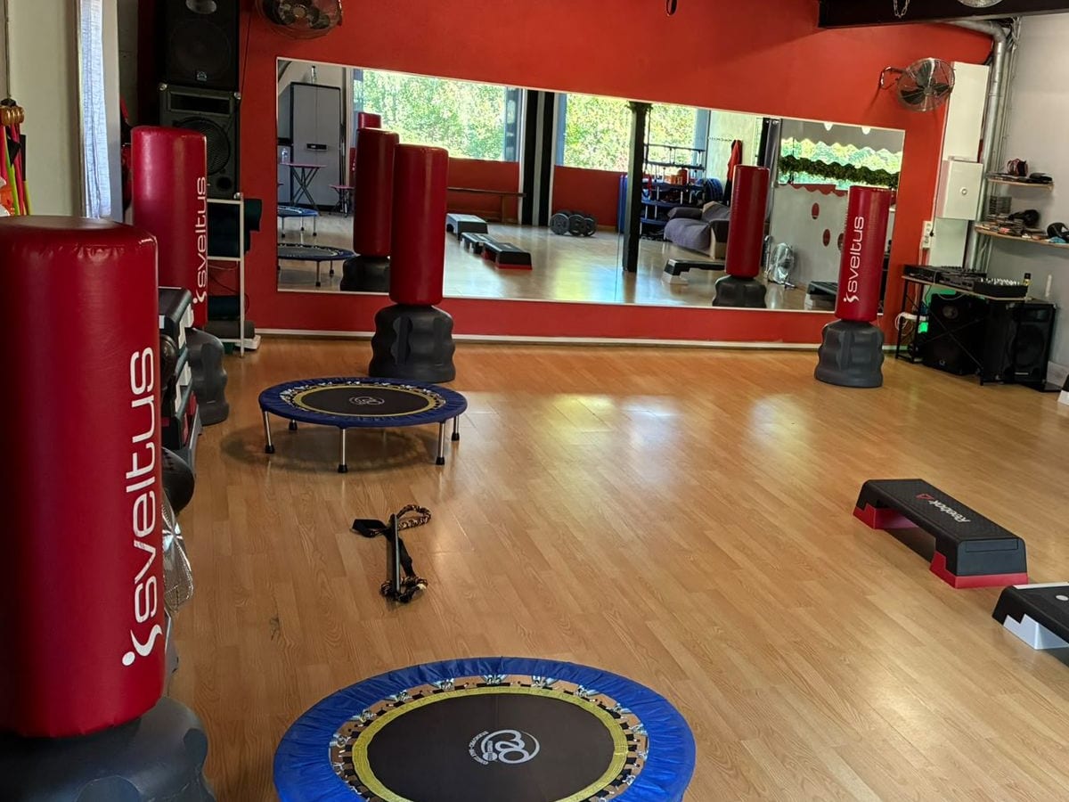 Sacs de frappe rouges et miroir dans la salle de cours collectifs